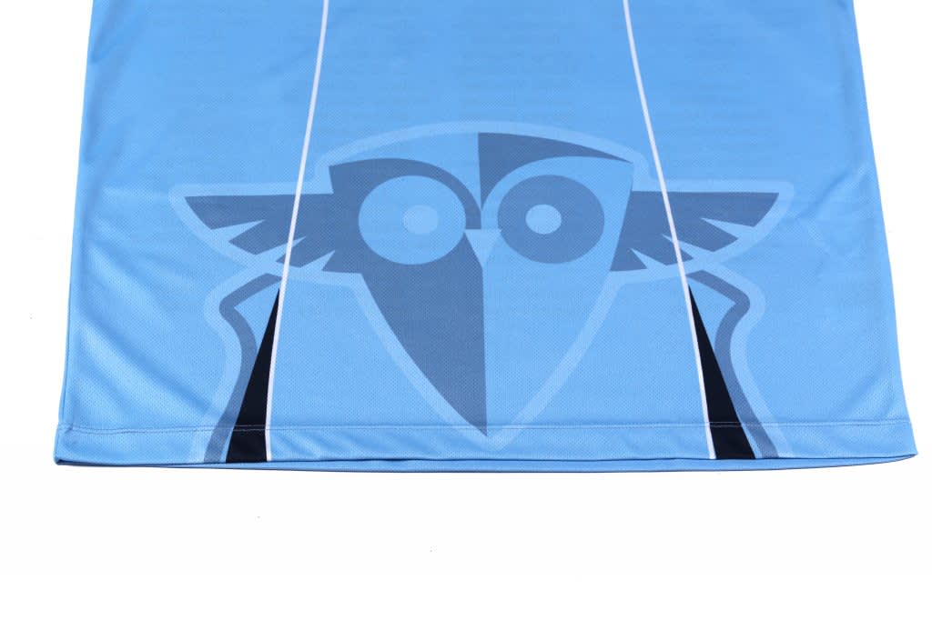 A blue sublimation leaver polo featuring a stylised design and a logo. The fabric appears smooth and lightweight.