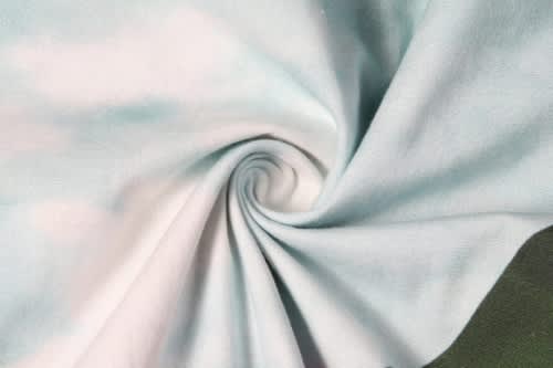 A light blue fabric with a soft, smooth texture, featuring a swirling pattern. The material is suitable for beach apparel.