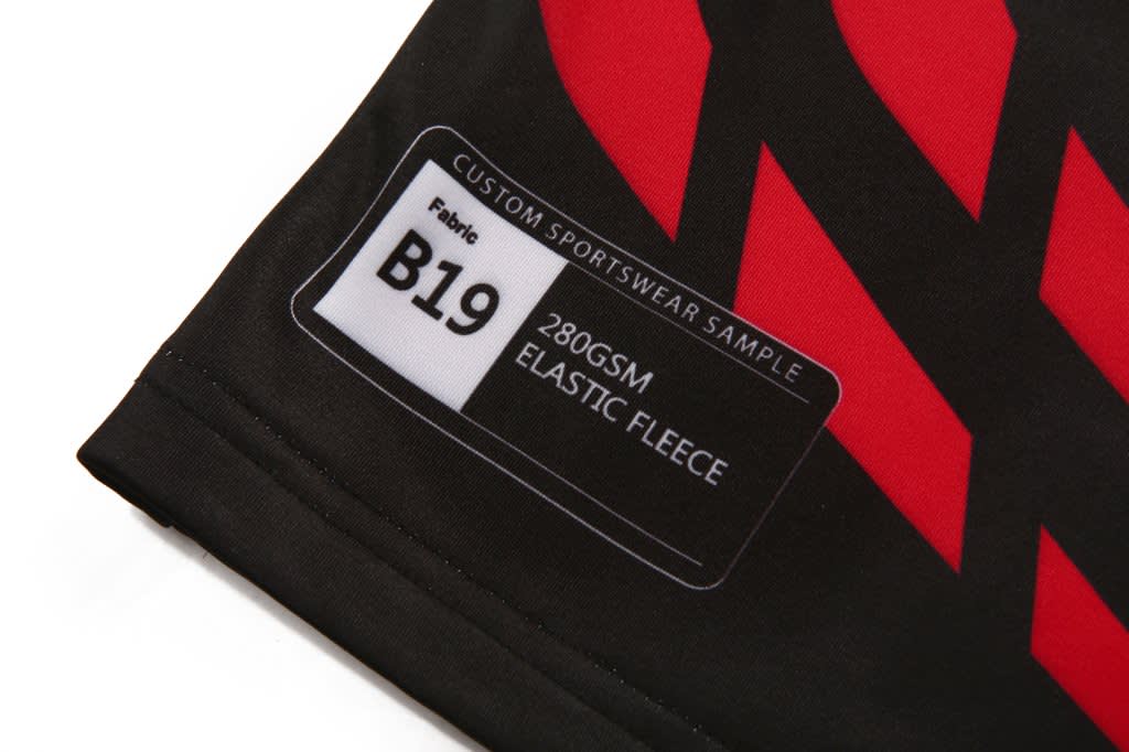 A heavy pullover featuring a red and black design, with a label indicating fabric type and weight.