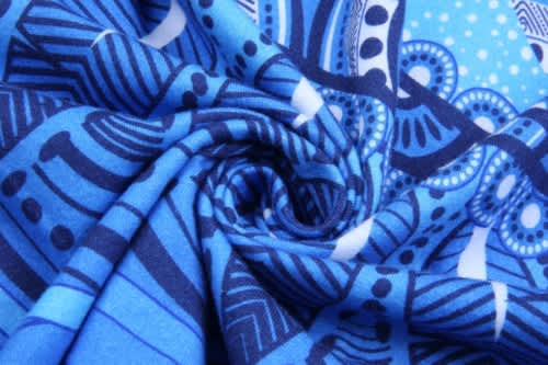 A blue Aboriginal cotton T-shirt featuring intricate patterns and swirls of various shades of blue.