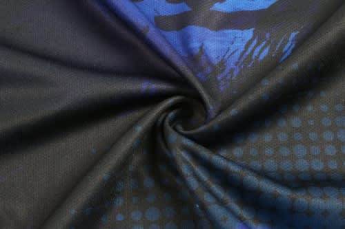 A swirling fabric display featuring a mix of deep blue and black patterns, suitable for cricket team wear.
