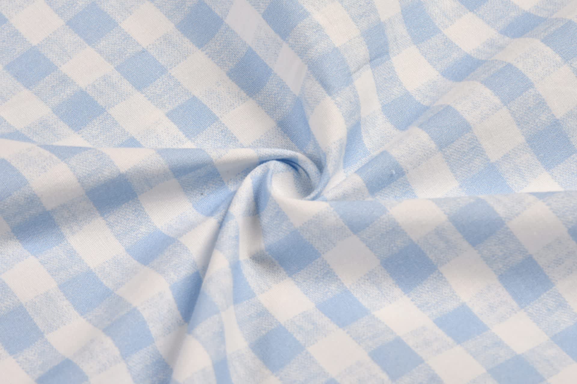 A close-up of blue and white checked cotton fabric, showcasing a soft, woven pattern.