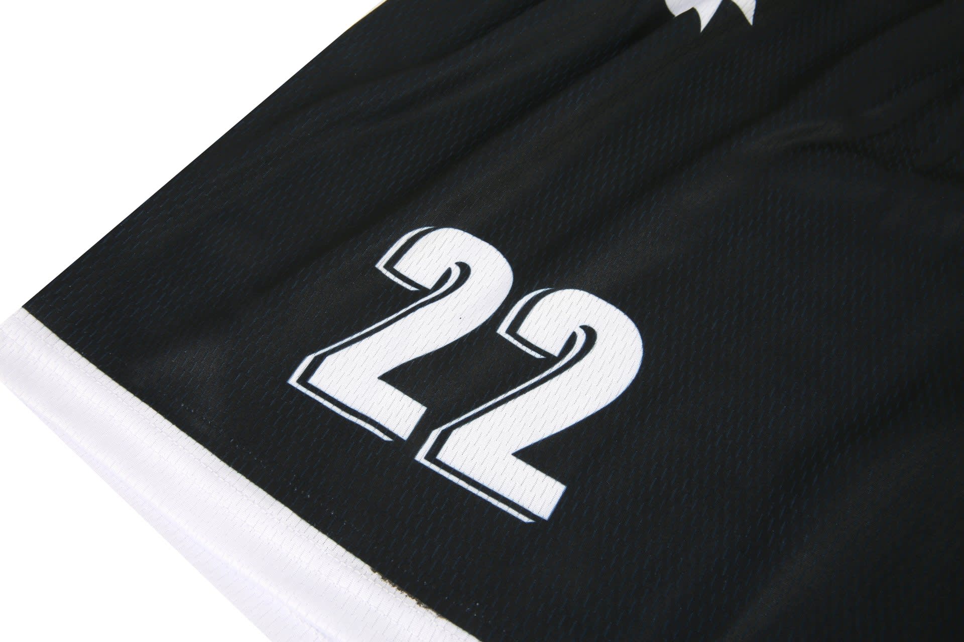 Black soccer shorts featuring white accents and the number 22, with a logo present on the fabric.