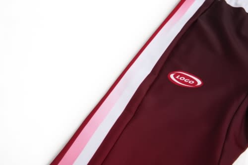 A maroon sports uniform featuring a logo and pink and white stripes along the side.