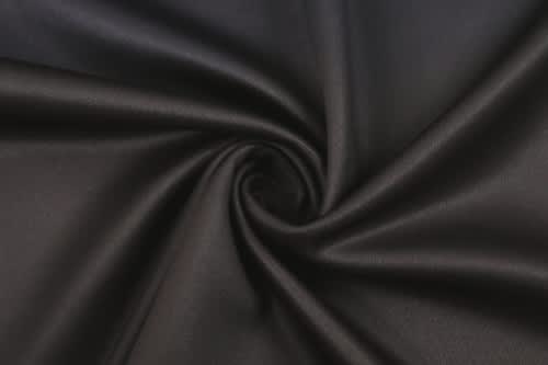 A smooth, black fabric arranged in a spiral pattern, showcasing its texture and sheen.