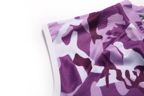 A close-up of a purple camouflage sports jersey featuring a logo on the neckline.