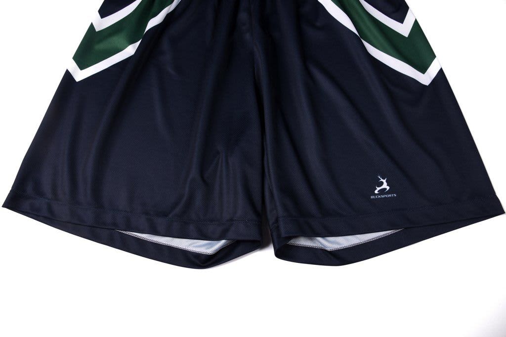 A pair of navy shorts with green and white graphic detailing, featuring a logo on the lower hem.