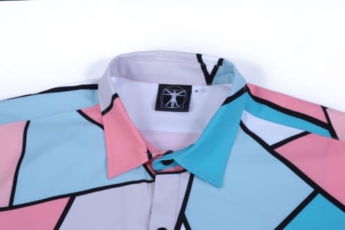 A multicoloured shirt featuring various geometric shapes in pink, light blue, and grey, with a logo on the collar.