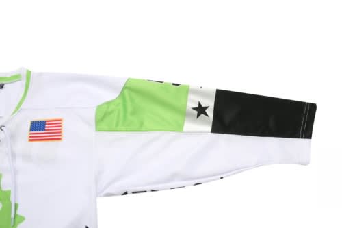 A white and green ice hockey racing suit with a black sleeve and a logo. It has an emblem on the front.