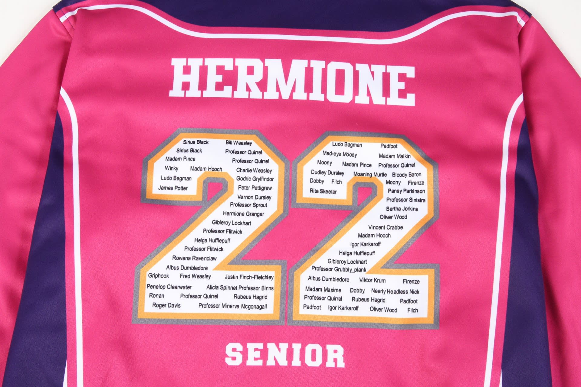 A pink varsity jacket featuring gold lettering and a list of names on the back, including "Hermione" and "22."