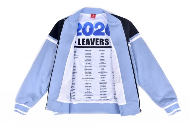 A bomber jacket in light blue and black with a printed interior listing names. It features a logo.