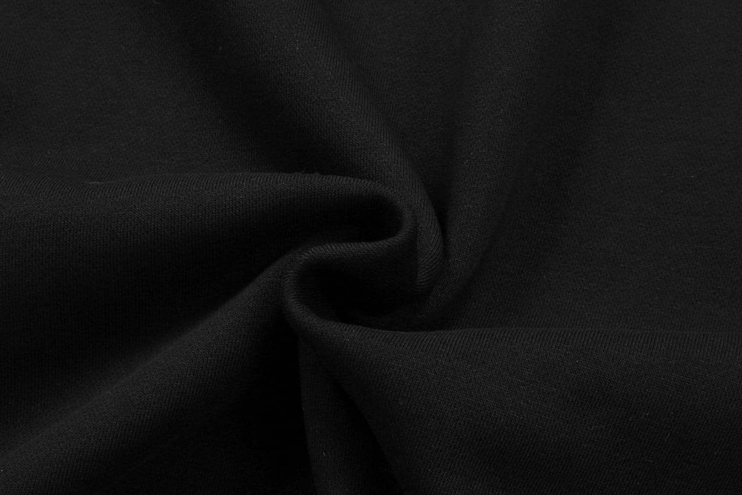 A black hoodie fabric, showing a close-up of the soft and smooth texture. The fabric is gathered in folds.