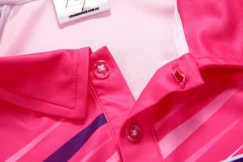 A close-up of a pink sports polo shirt featuring a collar and buttons, with striped design elements.