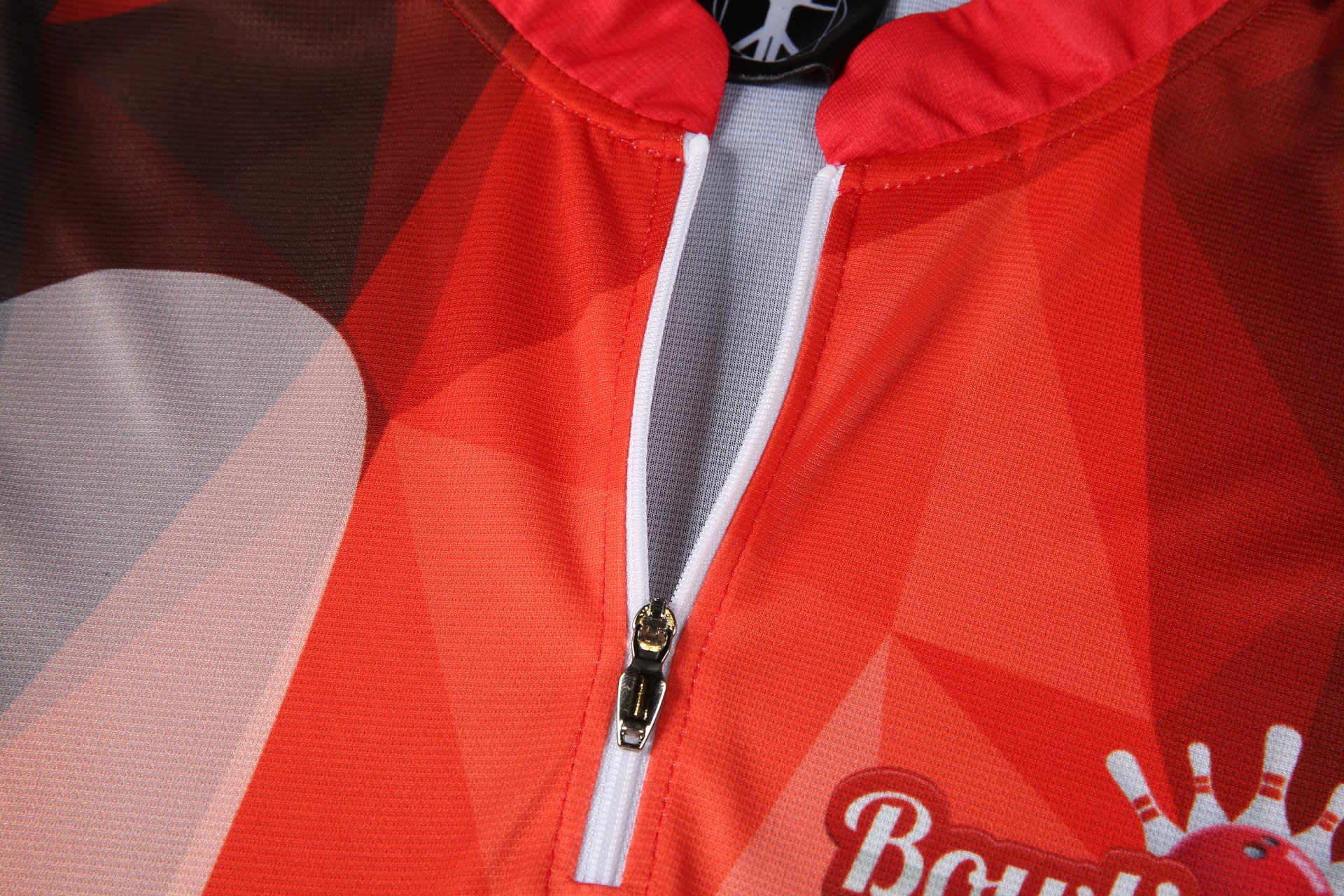 A red and grey bowling team shirt featuring a zip and a logo on the collar.