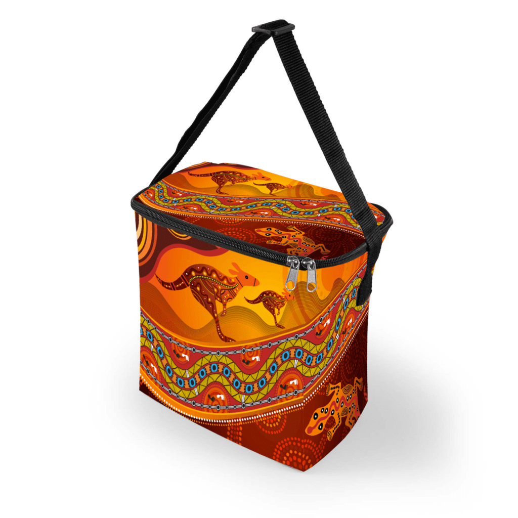 A cooler bag featuring an orange and red design with Aboriginal art patterns and a black strap.