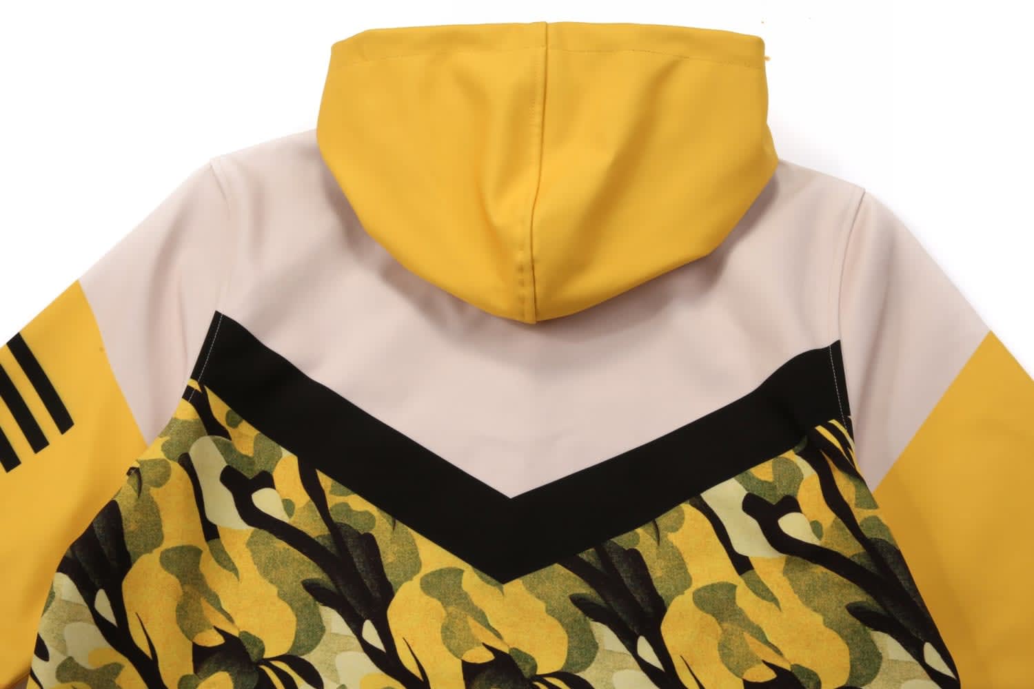 A yellow and beige jacket with a patterned design, featuring a hood and stripes on the sleeves.