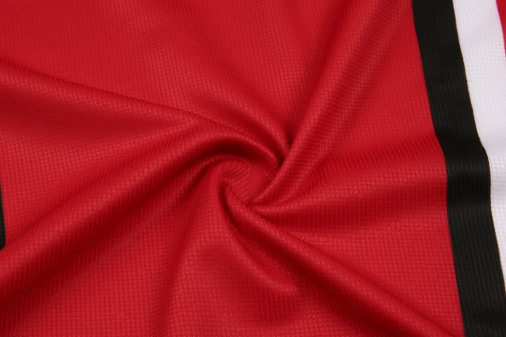 A fabric swatch featuring a smooth, red material with black and white stripes. It has a textured finish.