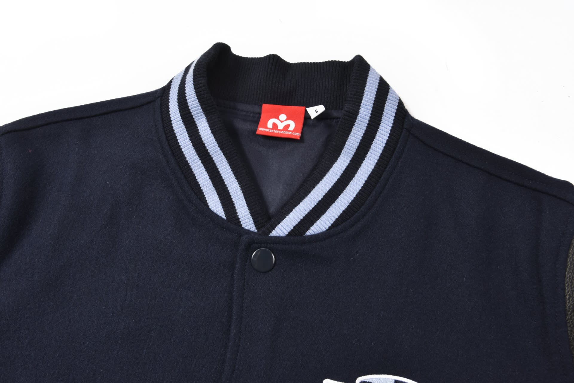 A navy blue letterman jacket featuring a striped collar and a logo on the front.