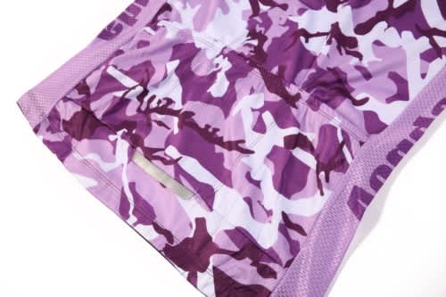 A purple camo-patterned sports jersey with mesh detailing and a logo.