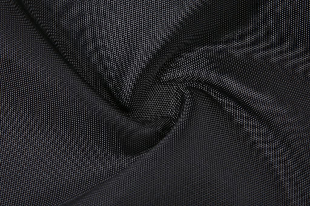 A close-up of black textured fabric, featuring a smooth, woven pattern. The material appears durable and lightweight.