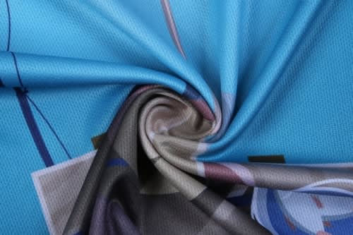 A close-up of a blue fabric featuring a design, showcasing a smooth texture suitable for sports uniforms.