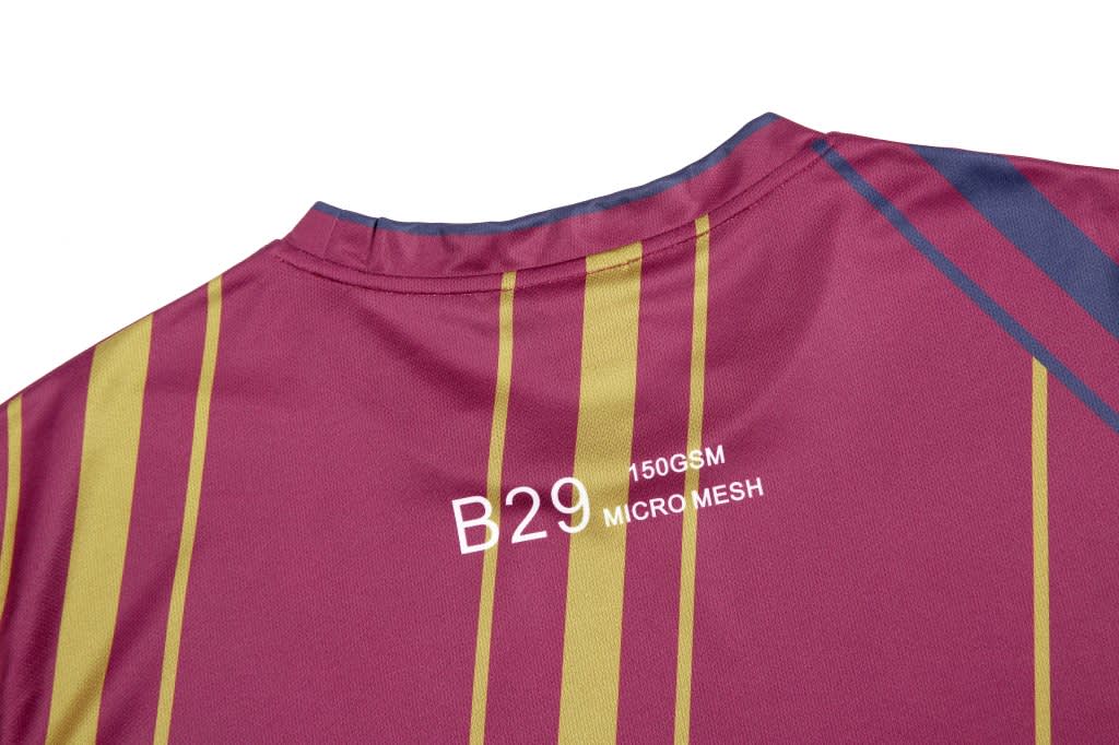 A maroon t-shirt featuring vertical stripes in yellow and blue, made from micro mesh fabric with a logo.