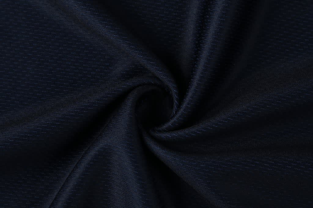A fabric swatch featuring a dark navy blue material with a subtle textured pattern, ideal for athletic wear.