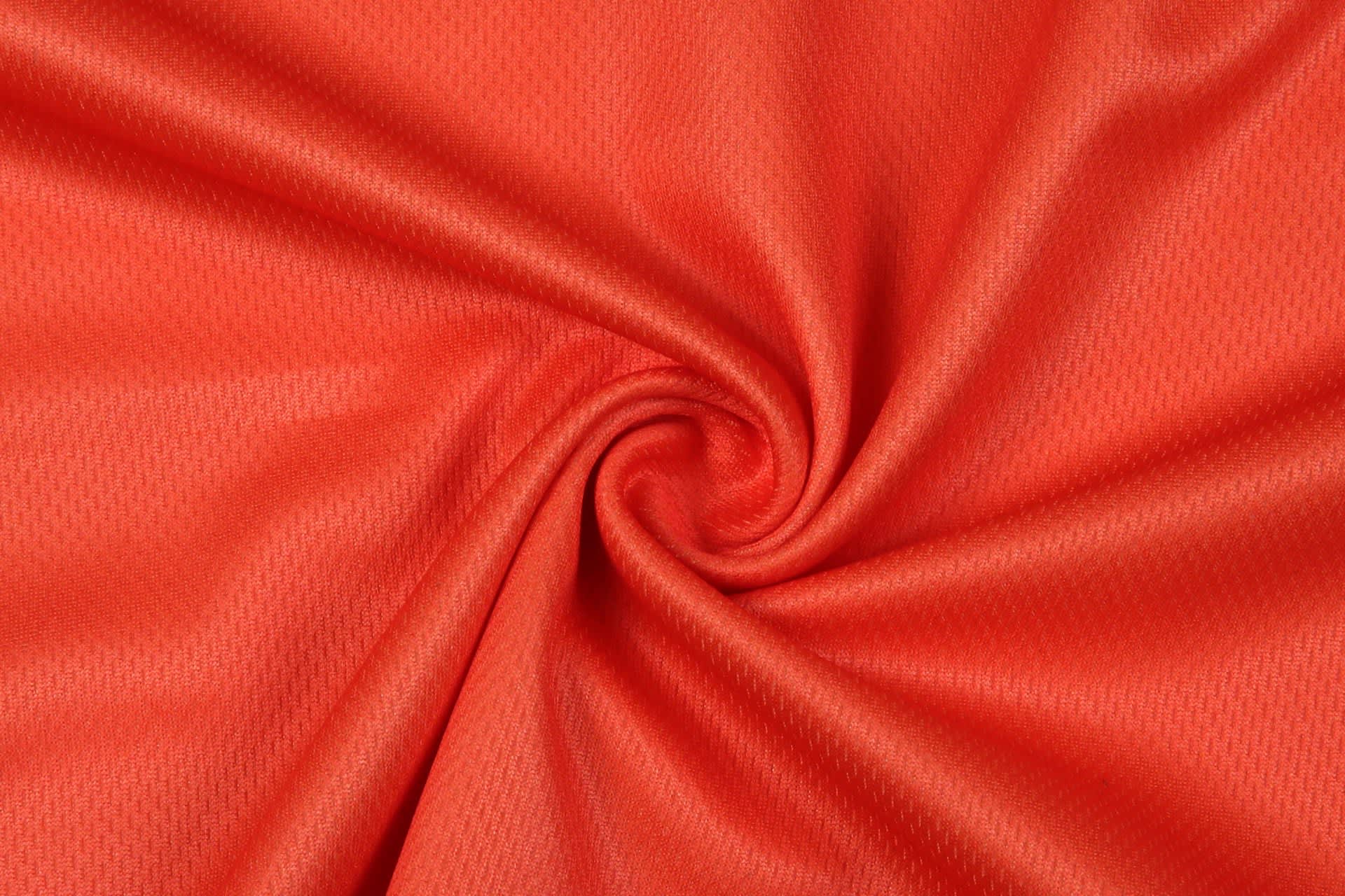 A vibrant orange fabric with a textured pattern, arranged in a spiral for a promotional product display.