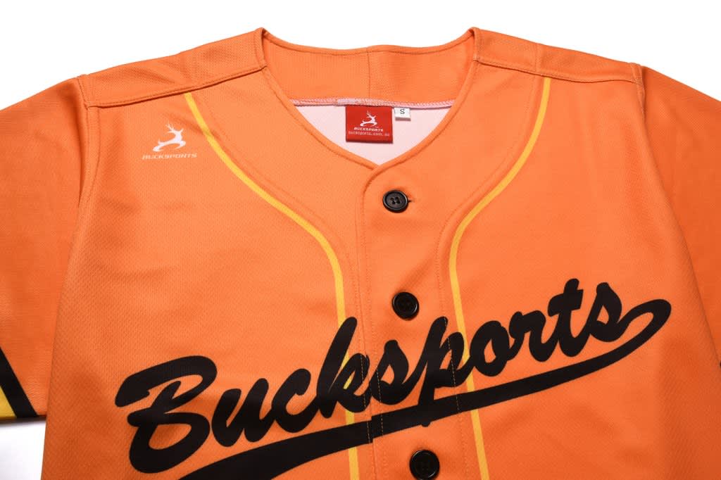 An orange baseball tee with full buttons, featuring black text and a logo on the chest.