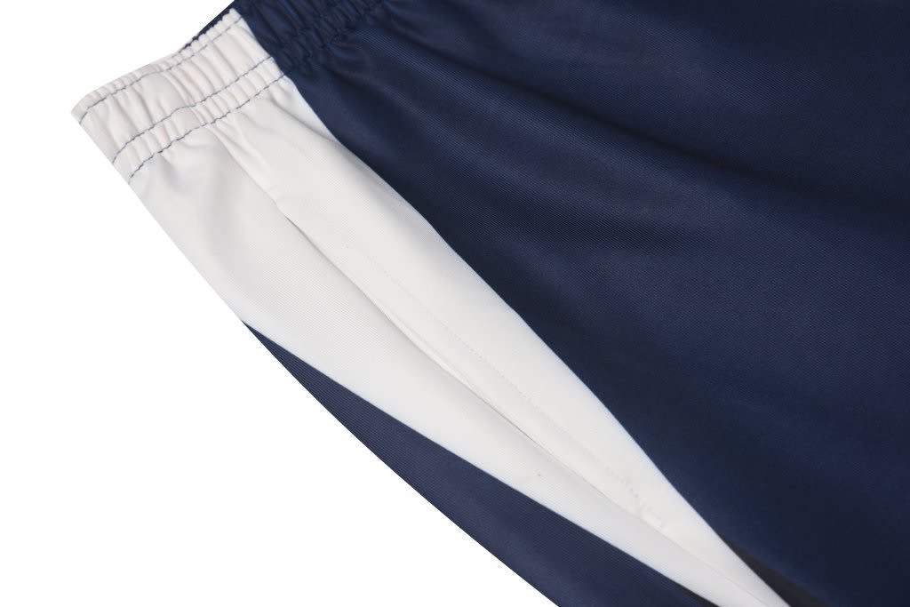 School track pants featuring navy blue and white panels, with an elastic waistband and a logo.
