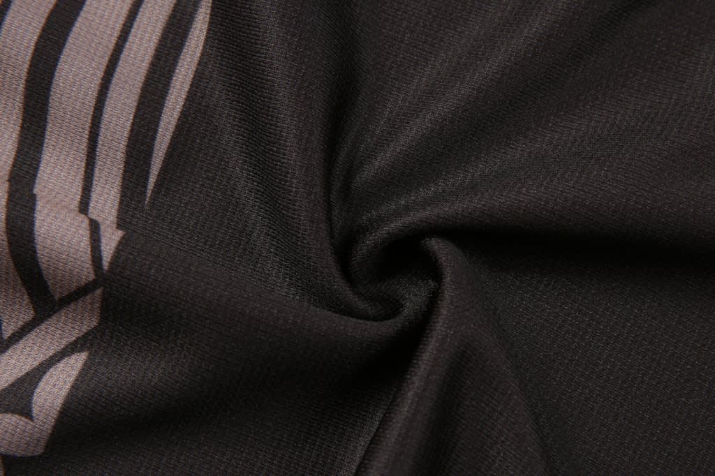 Aboriginal/Indigenous shorts in a black fabric with a patterned design, featuring a logo.