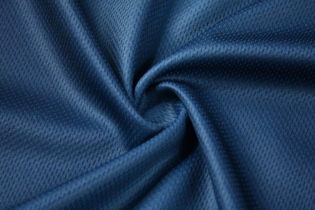 A textured, navy blue fabric displayed in a swirling pattern, highlighting its smooth surface.