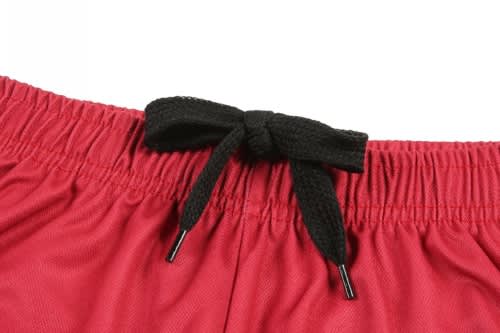 A red basketball uniform featuring an elastic waistband with a black drawstring. It has a logo on the side.