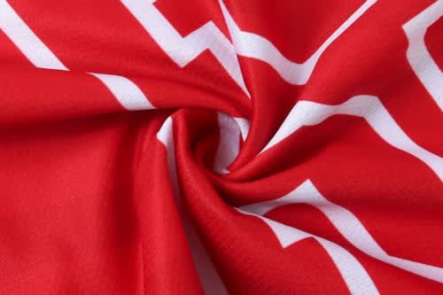 A red jersey featuring white stripes, showcasing a soft fabric texture and a logo.