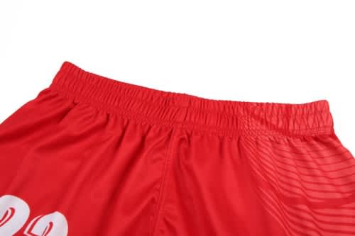 A red volleyball uniform with an elastic waistband, featuring a logo and a portion of the jersey's design.