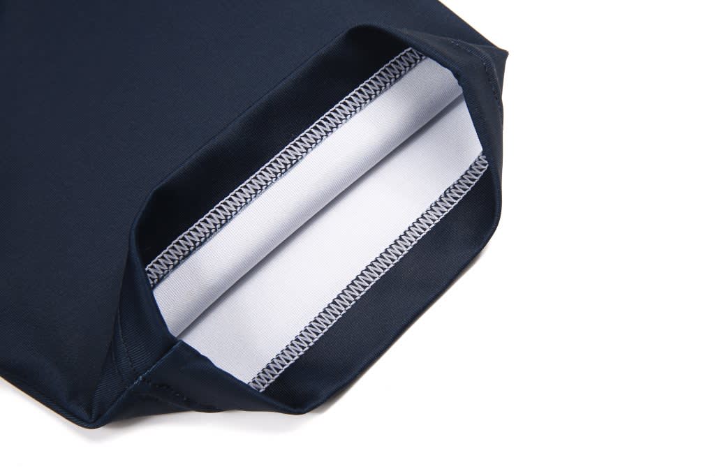 A close-up of a navy blue rugby tee with a white interior lining and neat stitching details.