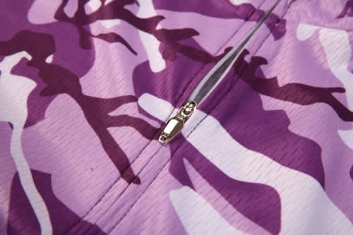 A purple and white camo-patterned sports jersey featuring a central zip closure and a subtle branding logo.
