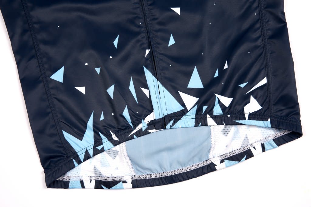 A waterproof woven vest in black with a blue geometric pattern near the hem. It features a logo on the fabric.