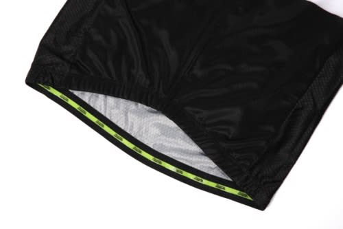 A close-up of black sports jersey fabric with a green trim and an attached branding logo.