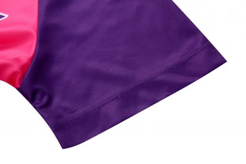 A close-up of a sports uniform, featuring a vibrant pink and purple colour scheme with a logo.