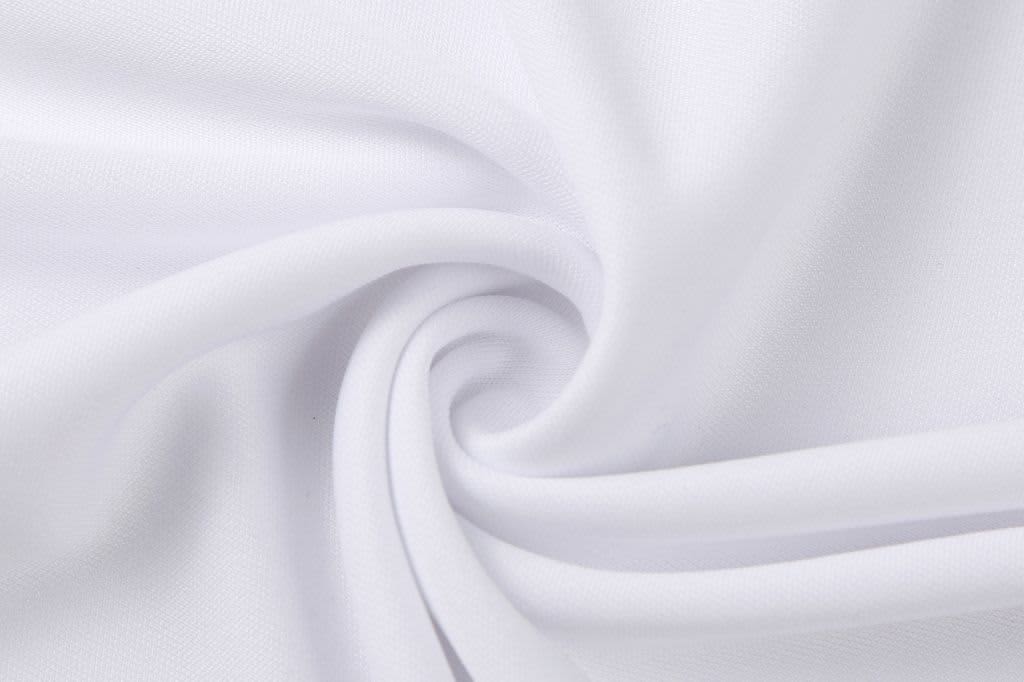 A white fabric swirled in a spiral pattern, showcasing a smooth, soft texture. It has a subtle sheen.