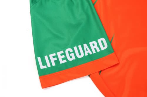 A bright orange and green quarter zip uniform with "LIFEGUARD" text, featuring a simple design and logo.