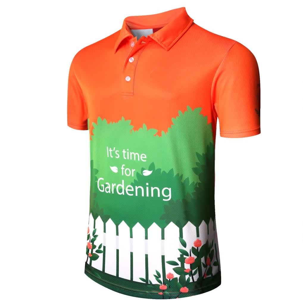 An orange polo shirt with a green gardening theme featuring a white fence and floral designs. It has a logo.