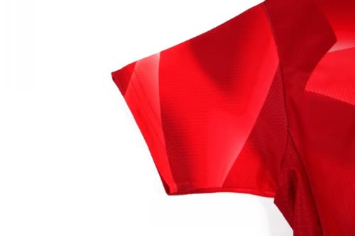 A bright red cycling jersey featuring a stylish design and a logo.