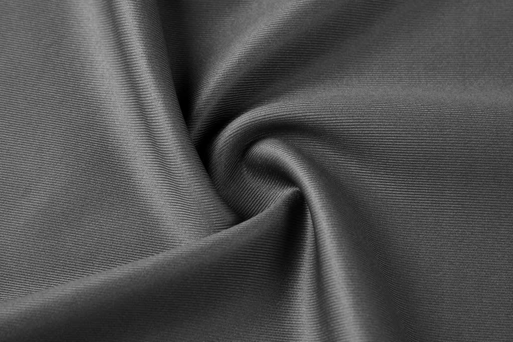 A close-up of grey fabric, showcasing a smooth, textured surface with fine ribbed patterns.