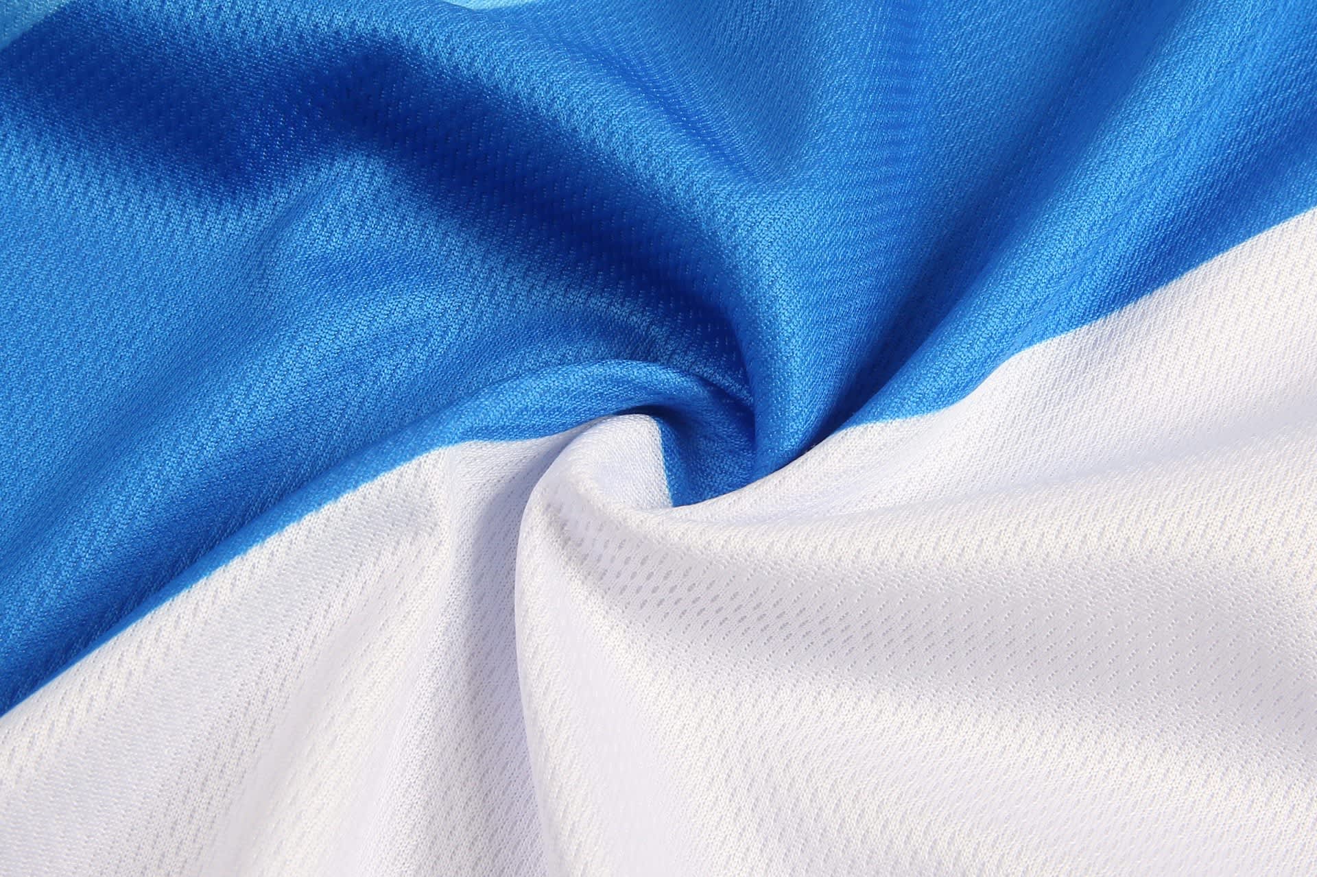 Aboriginal shorts featuring a design in blue and white fabric with a textured pattern and a logo.