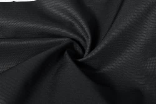 A close-up of black soft shell fabric, showcasing its textured surface and smooth finish.
