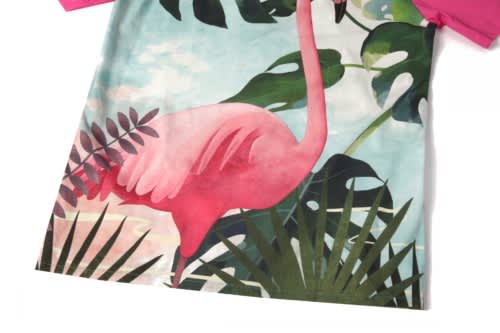 A vibrant beach shirt featuring a pink flamingo design and green tropical foliage. Short-sleeved with a colourful pattern.