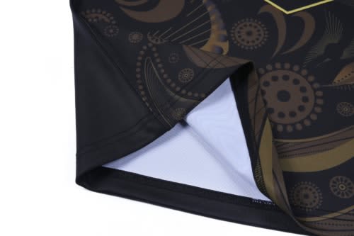 A black hoodie featuring intricate Aboriginal-inspired patterns in gold tones, with a branded logo.