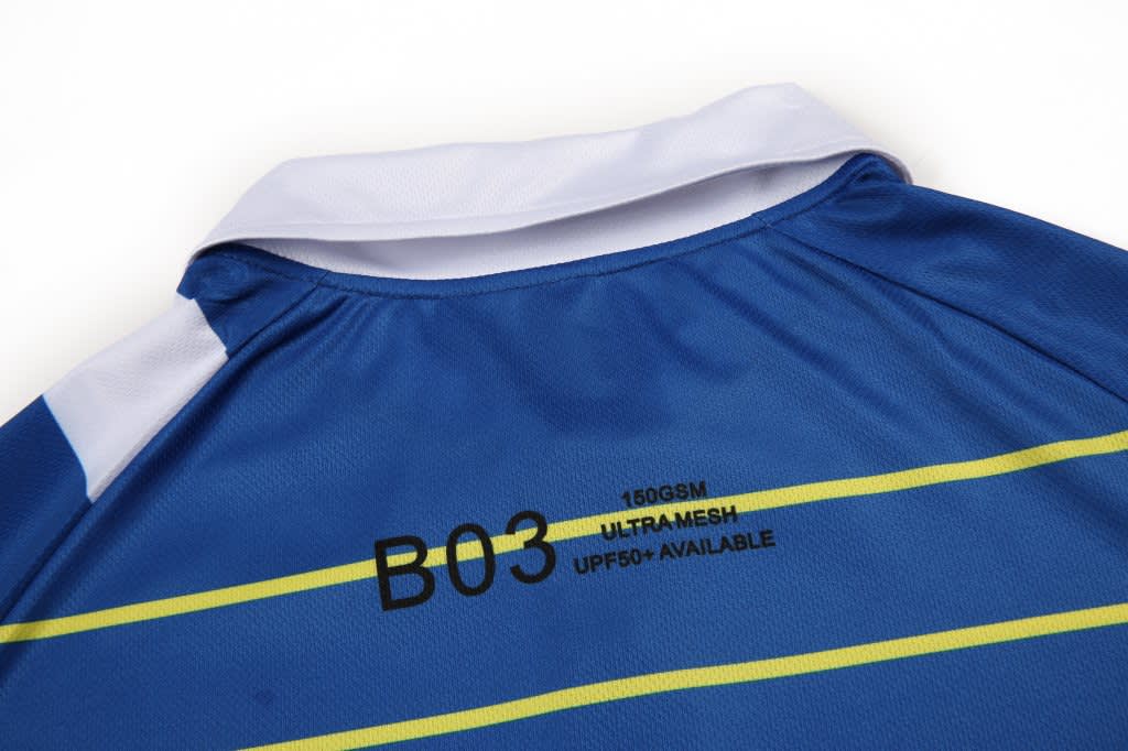 A blue polo shirt made of ultra mesh fabric featuring yellow stripes and a white collar, with a logo on the collar.